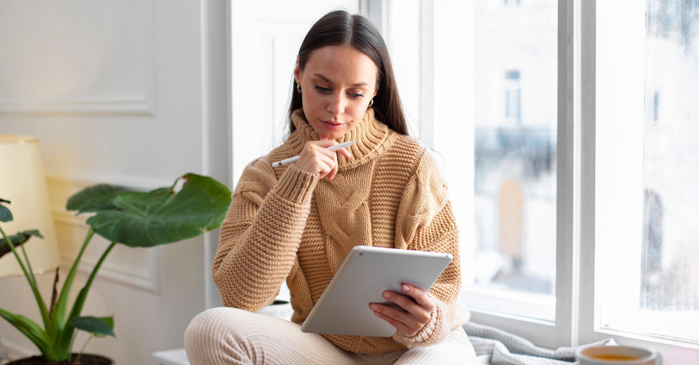 Woman using a tablet at home while connected to the internet